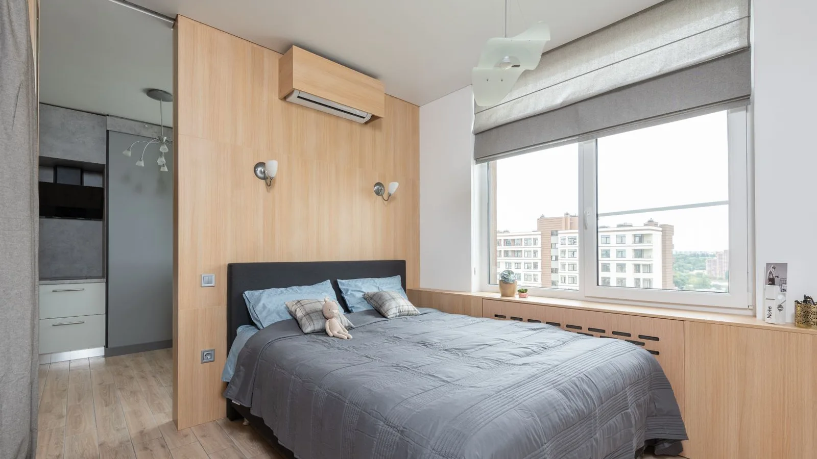 Small bedroom with a wall-mounted ductless mini split indoor unit above the bed, the kind of 250 sq ft room a 6,000–9,000 BTU DIY mini split from MRCOOL or Zone Air is sized for